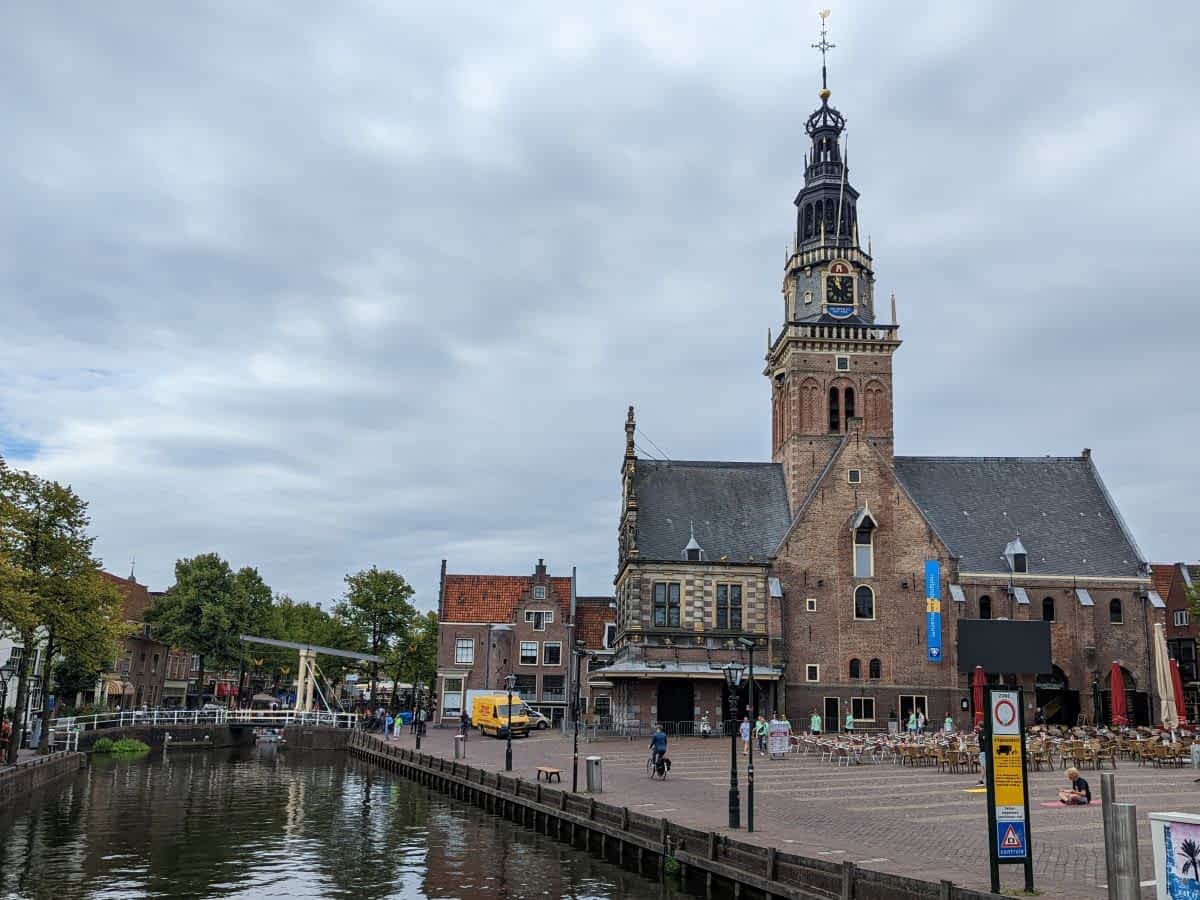 Das historische Waaghaus (Waaggebouw) in Alkmaar an einem belebten Platz neben einer Gracht.